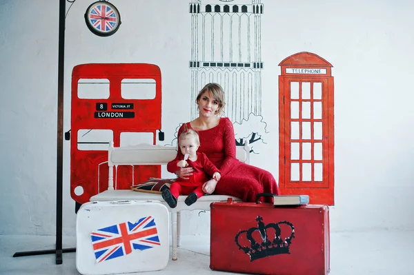 Encantador bebé y su madre en vestido rojo, fondo tema de Inglaterra — Foto de Stock