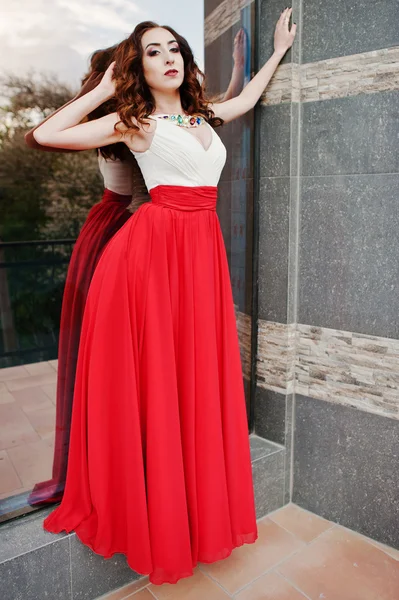 Портрет модної дівчини на червоній вечірній сукні позують на спині — стокове фото