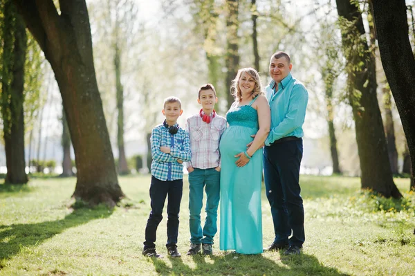 Retrato de família grávida feliz com dois filhos, vestida em um tu — Fotografia de Stock