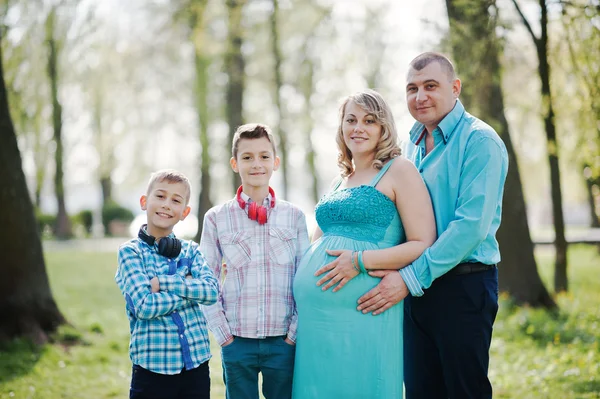 Porträt einer glücklichen schwangeren Familie mit zwei Söhnen, gekleidet in ein Tuch — Stockfoto
