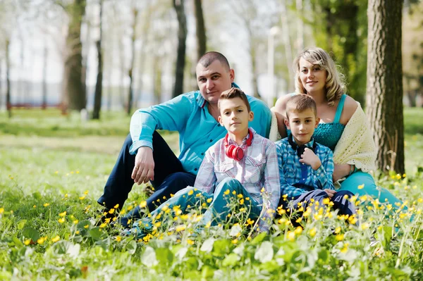 Šťastná těhotná rodina se dvěma syny, oblečená v tyrkysové sraženinu — Stock fotografie