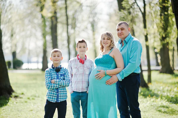 Portret szczęśliwej rodziny w ciąży z dwoma synami, ubrany w tu — Zdjęcie stockowe