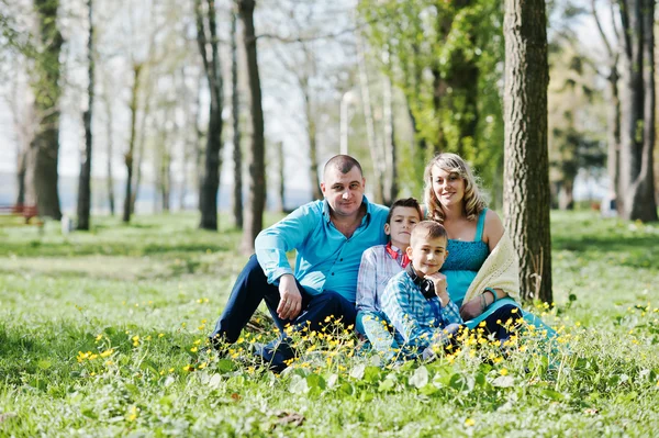 Lycklig gravid familj med två söner, klädd i en turkos propp — Stockfoto