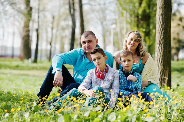 Щаслива вагітна сім'я з двома синами, одягнена в бірюзовий згусток — стокове фото
