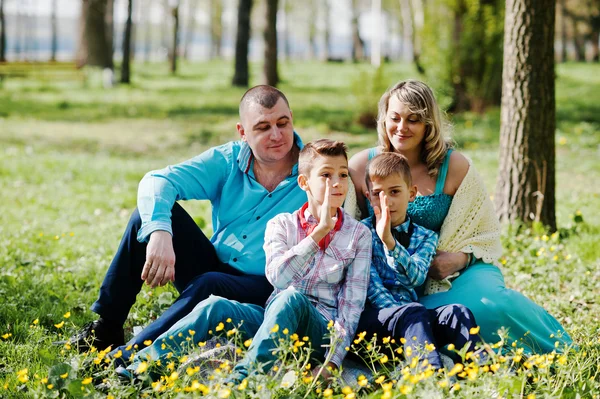 Щаслива вагітна сім'я з двома синами, одягнена в бірюзовий згусток — стокове фото