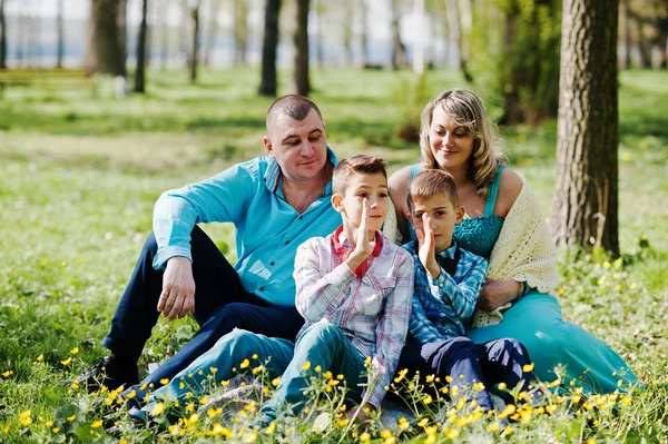 Glückliche schwangere Familie mit zwei Söhnen, gekleidet in ein türkisfarbenes Blutgerinnsel — Stockfoto