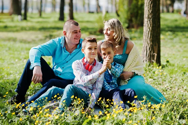 Glückliche schwangere Familie mit zwei Söhnen, gekleidet in ein türkisfarbenes Blutgerinnsel — Stockfoto