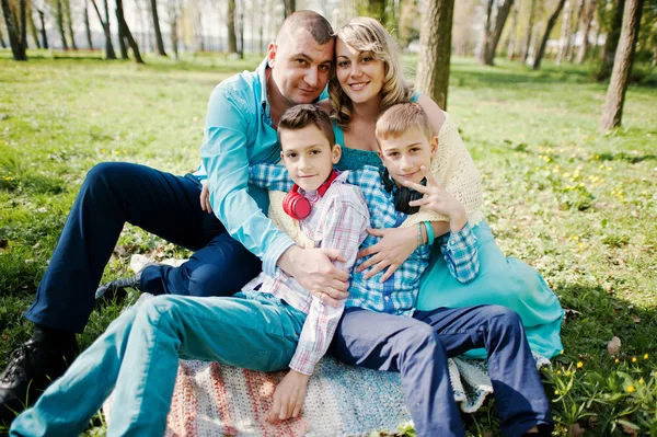 Gelukkige zwangere familie met twee zonen, gekleed in een turquoise stolsel — Stockfoto