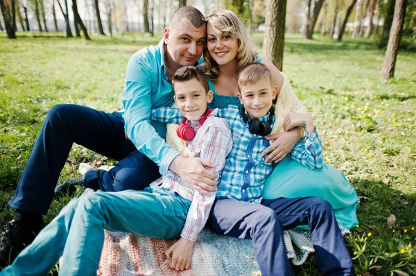 Lycklig gravid familj med två söner, klädd i en turkos propp — Stockfoto