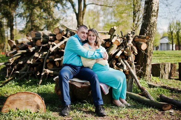 Feliz familia embarazada vestida con una ropa turquesa sentada en —  Fotos de Stock