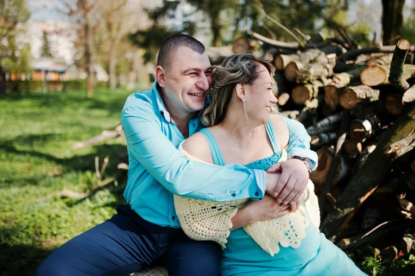 Счастливая беременная семья, одетая в бирюзовую одежду, сидит на — стоковое фото