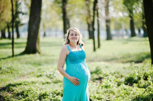 Портрет счастливой беременной женщины в бирюзовом платье на — стоковое фото