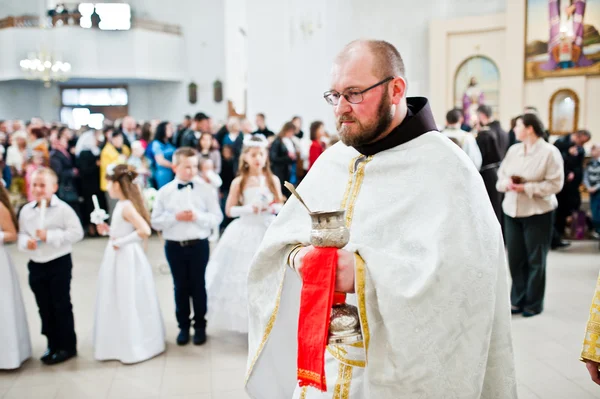 LVIV, UCRANIA - 8 DE MAYO DE 2016: Sacerdote en la ceremonia de un Primer Commu — Foto de Stock