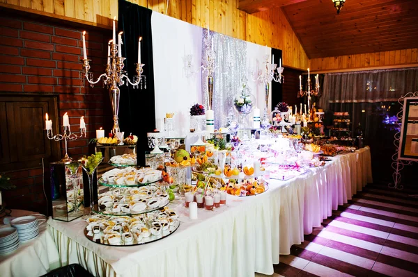 Mesa de recepção de casamento elegante com comida e decoração. Queimando ca — Fotografia de Stock