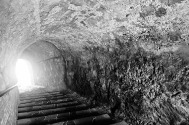 Tünelin sonunda bir ışık ile taş mağara. Korkunç siyah bir