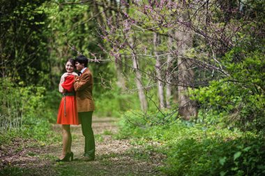 Bahar dalları ile ormanda sarılma çift. Ve şık adam