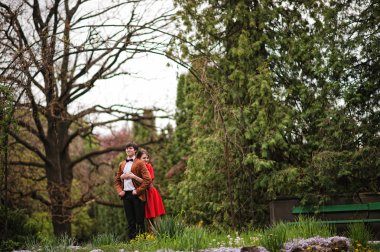 Park bahçe arka plan büyük kemer de aşık sarılma çift. Styli