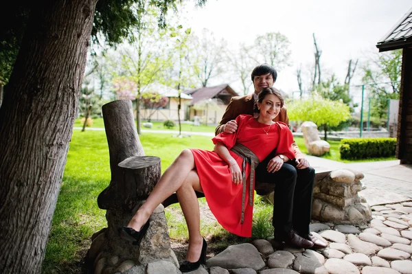 Couple sitting on bench. Stylish man at velvet jacket and girl i — Stock Photo, Image