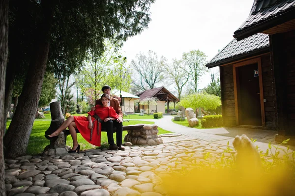 Bankta oturan bir çift. Şık erkek kadife ceket ve kız ben