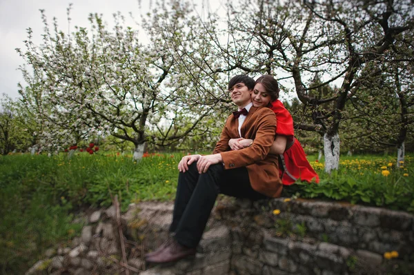 Couple hugging in love near blooming trees garden. Stylish man a — Stock Photo, Image