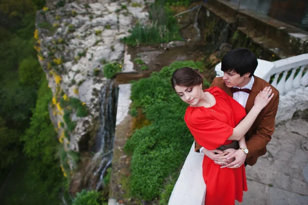 Couple hugging in love background fantastic cliff with waterfall