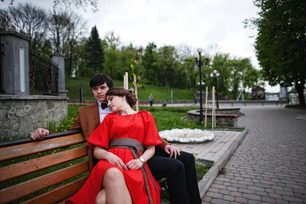 Paar auf der Bank liegend. stilvoller Mann mit Samtjacke und Mädchen — Stockfoto