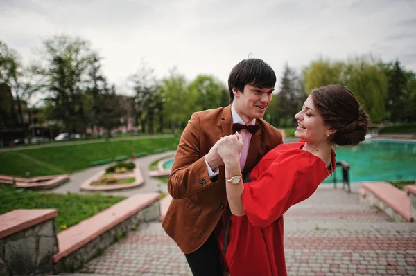 Um casal a abraçar-se no amor perto da fonte. Homem elegante no veludo jack — Fotografia de Stock