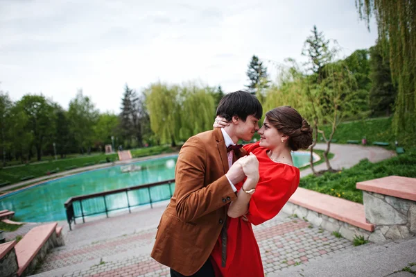 Um casal a abraçar-se no amor perto da fonte. Homem elegante no veludo jack — Fotografia de Stock