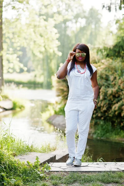 African kobieta o krajowych białe szaty i okulary przeciwsłoneczne — Zdjęcie stockowe