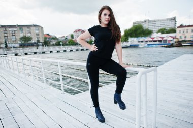 Siyah elbiseli genç kıza iskelede poz verdi.