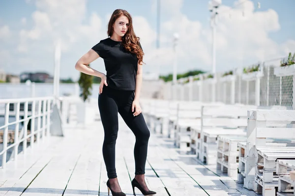 Ung flicka på svarta kläder som poseras på piren — Stockfoto