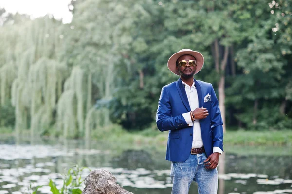 Retrato de hombre negro rico con estilo en chaqueta azul, sombrero y sungl — Foto de Stock