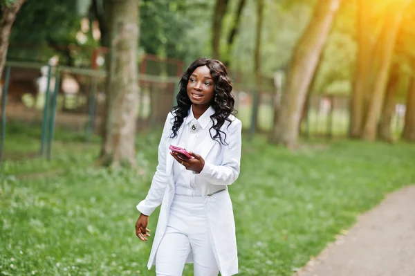 Elegante chica afroamericana negra caminando en el parque con móvil — Foto de Stock