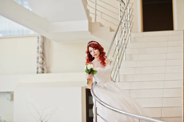 Charming red-haired bride with wedding bouquet at hand posed on — Stock Photo, Image