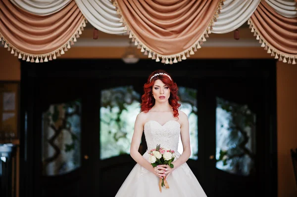 Charming red-haired bride with wedding bouquet at hand posed aga — Stock Photo, Image