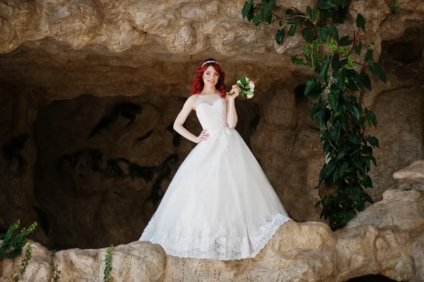 Charmante mariée aux cheveux roux modèle avec bouquet de mariage à portée de main pos — Photo