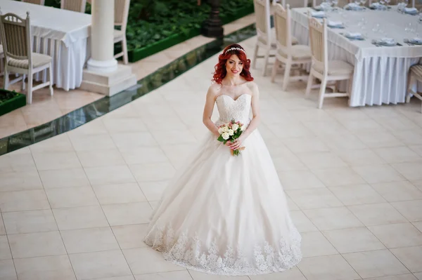 Charming red-haired bride with wedding bouquet at hand posed aga — Stock Photo, Image