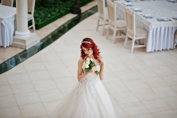 Charming red-haired bride with wedding bouquet at hand posed aga — Stock Photo, Image