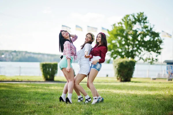 Три счастливые девушки в коротких шортах и венки на головах танцуют — стоковое фото