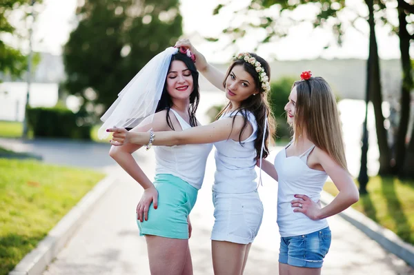 Drie vrolijke en sexy meisjes op korte broek en witte shirts pose — Stockfoto