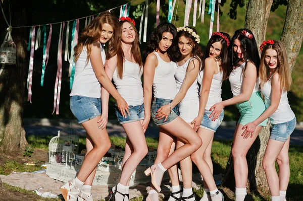 Siete chicas felices y sexy en pantalones cortos y camisas blancas posan — Foto de Stock