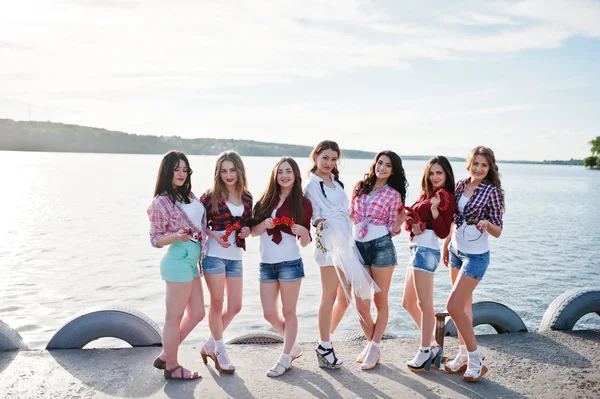 Siete chicas en pantalones cortos posados en el lago puesta del sol en la despedida de soltera — Foto de Stock