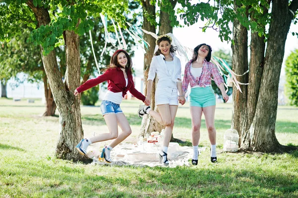 Tres hermosas chicas alegres en pantalones cortos saltando backgroun — Foto de Stock