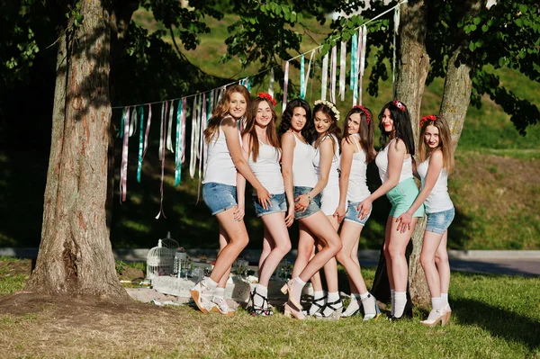 Siete chicas felices y sexy en pantalones cortos y camisas blancas posan —  Fotos de Stock