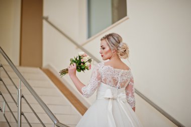 Muhteşem sarışın gelin merdiven kapalı büyük düğün Salonu'nda poz verdi.