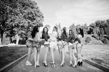 Yedi mutlu ve seksi kız Arkadan Görünüm kısa şort holding 