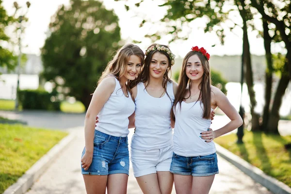 Tres chicas felices y sexy en pantalones cortos y camisas blancas posan —  Fotos de Stock