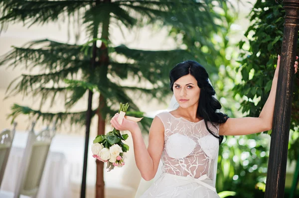 Pokušení model bruneta nevěsta na vzrušující svatební šaty představuje — Stock fotografie