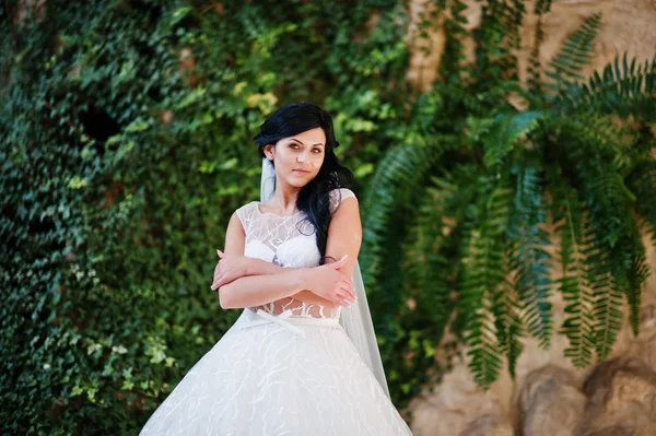 Pokušení model bruneta nevěsta na vzrušující svatební šaty pozadí — Stock fotografie