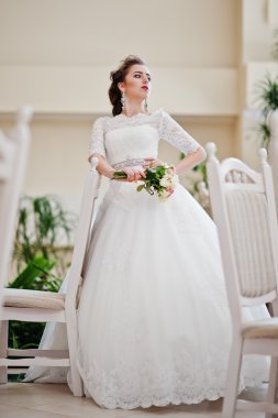 Sandalyeler ve tabl yakın düğün salonunda güzel gelin portresi